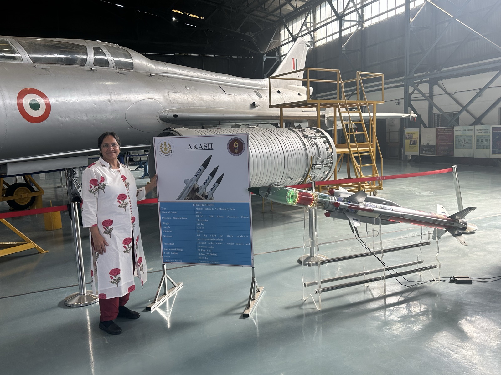 Prameela Kalive beside an AKASH missile display from her DRDO years